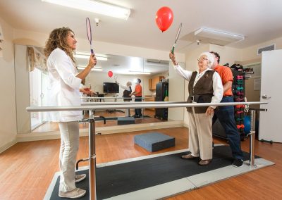 two rehab therapists and a resident in the rehab gym at Monterey Care Center