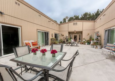 outdoor courtyard and soft seating and flowers on the table at Monterey Care Center